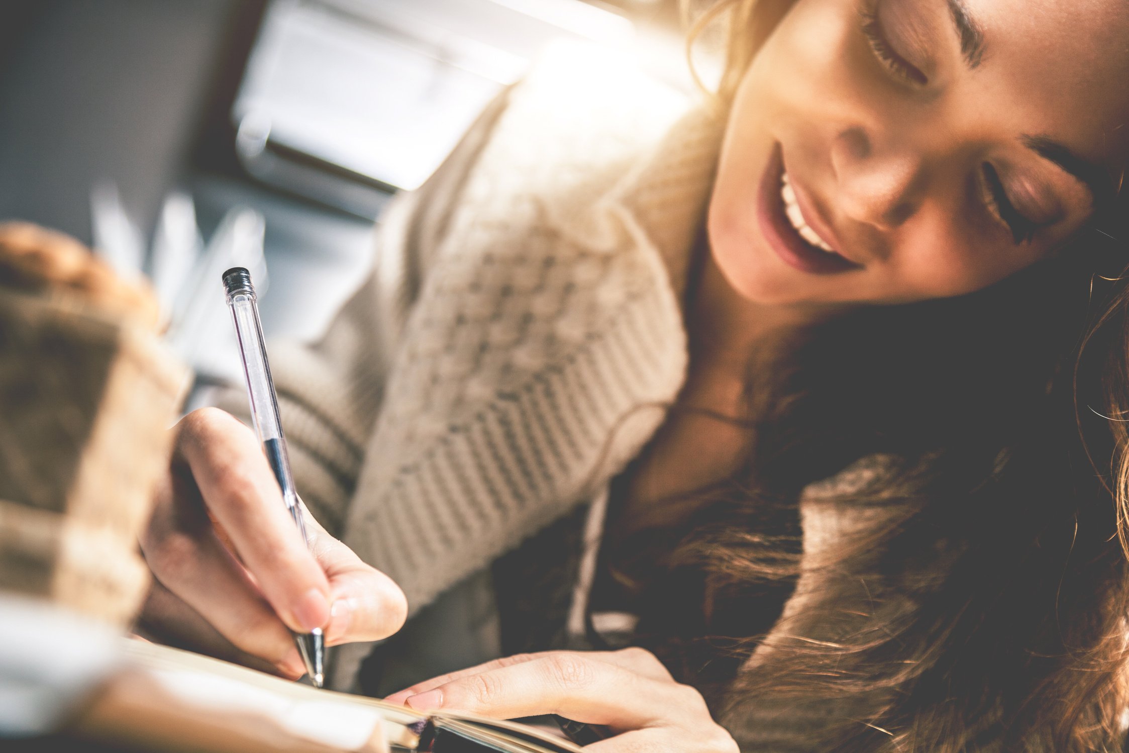 Young woman writing on diary